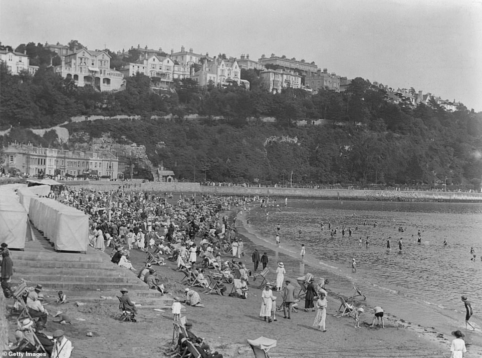 На этом снимке, датированном 1922 годом, отдыхающие отдыхают на пляже Torre Abbey Sands. Совет по туризму региона сообщает, что в этот период «Английская Ривьера привлекала множество богатых семей, которые сначала приезжали сюда за здоровьем и чтобы избежать холодных зим в остальной части Британии».