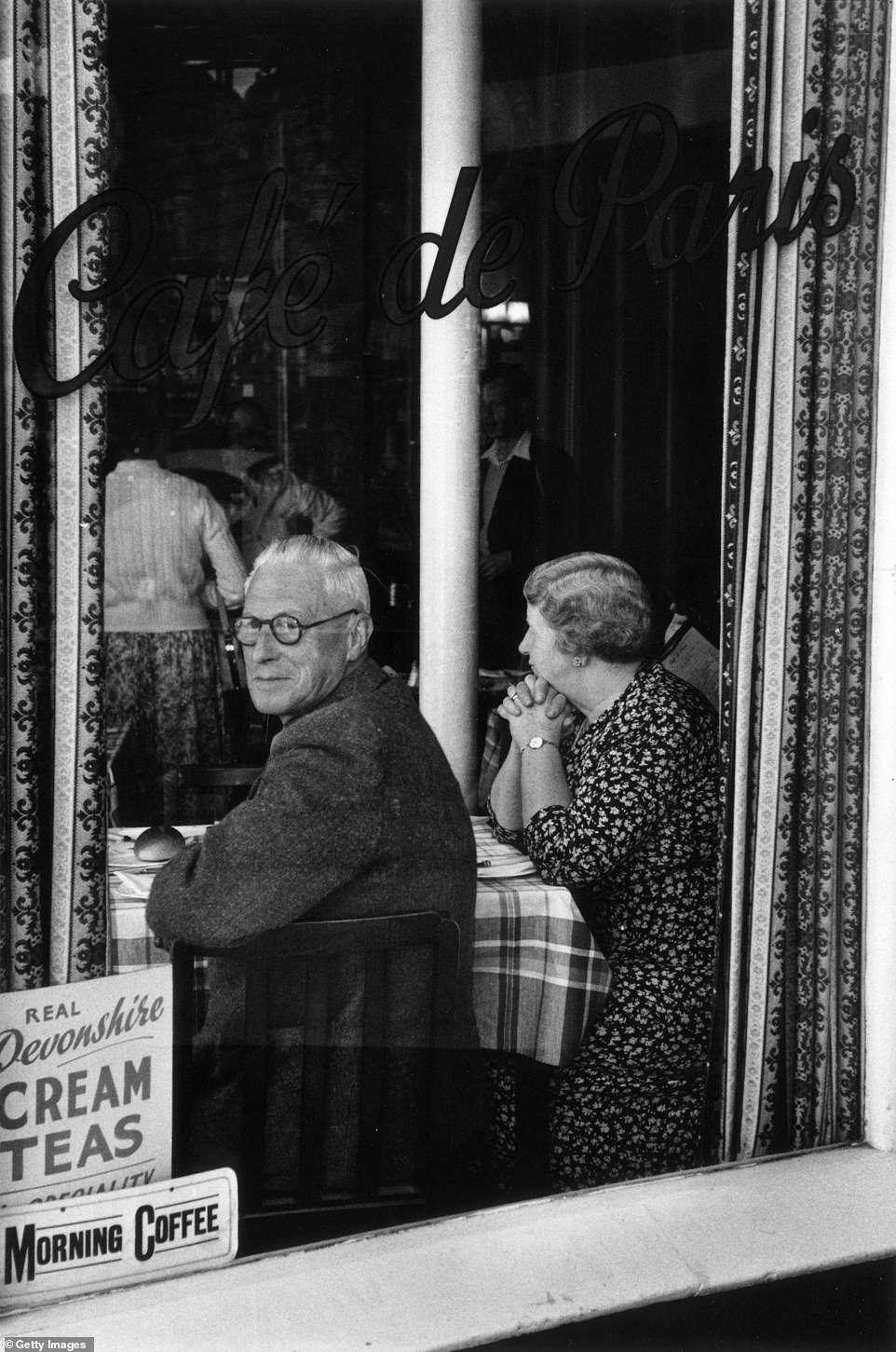 Посетители кафе Cafe de Paris в Торки в 1954 году. Вывеска на окне рекламирует «настоящие девонширские сливочные чаи», которые отличаются от корнуоллских сливочных чаев тем, что в Девоне сливки добавляются перед джемом, а в Корнуолле джем добавляют перед сливками.
