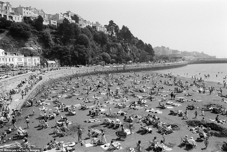 На этой фотографии изображены отдыхающие, наслаждающиеся пляжем Torre Abbey Sands в центре Торки, в 1984 году. Совет по туризму Английской Ривьеры сообщает: «Этот восхитительный пляж является частью Английской Ривьеры и оправдывает свое название своими потрясающими песками, видами и солнцем».