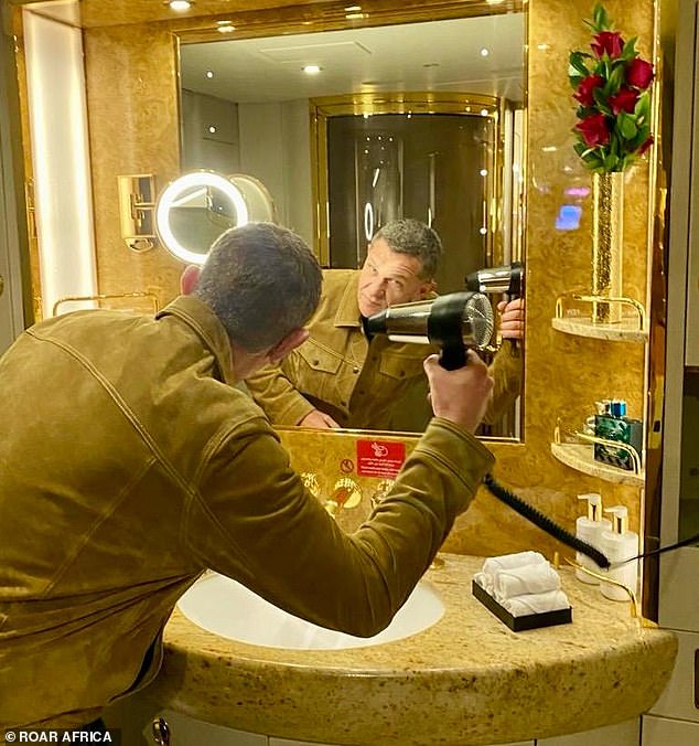 Гость пользуется феном в душевой спа-зоне частного самолета.