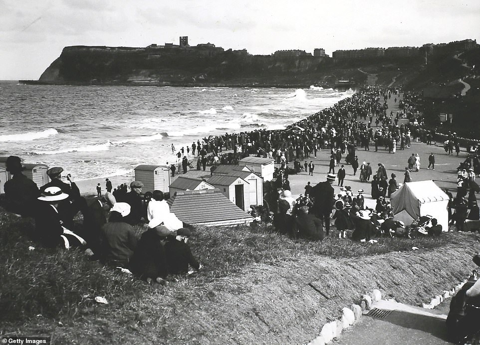 Туристы фотографируются в Северной бухте Скарборо в 1913 году. Руины замка Скарборо, средневековой крепости, видны на холме в задней части кадра. Гражданское общество Скарборо отмечает, что руины «остаются самой известной достопримечательностью города».